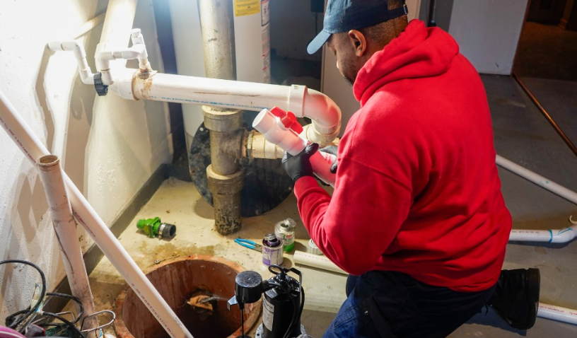 Plumber working on drain pipes